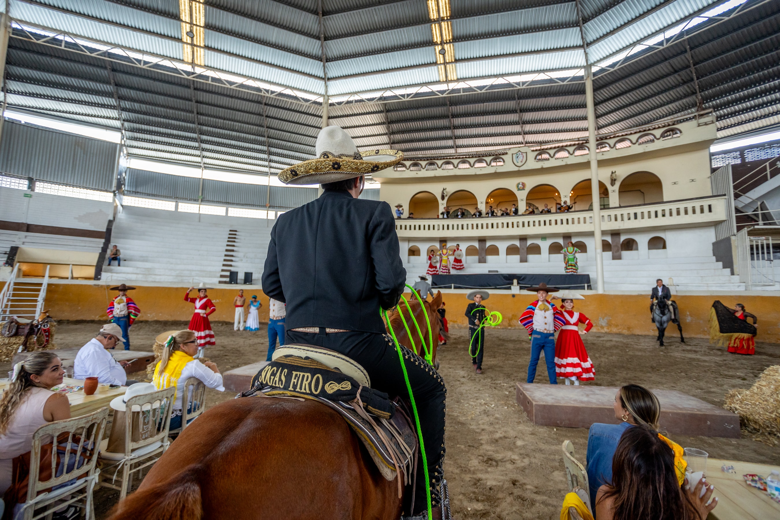 Charro a caballo observando espectáculo de día en el Lienzo Charro de Jalisco