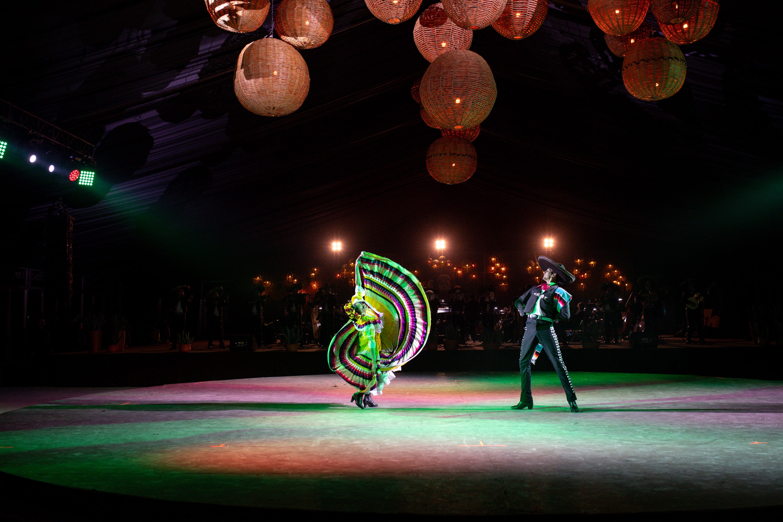 Bailarina folklórica con charro bajo lámparas de mimbre